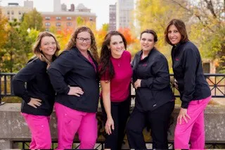 Team photo posing outside with trees in background